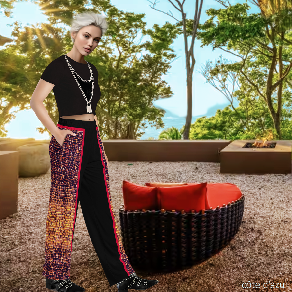 Garden setting right side view of trans model wearing DESTINY unisex black and gold wide leg pants with crimson trims 