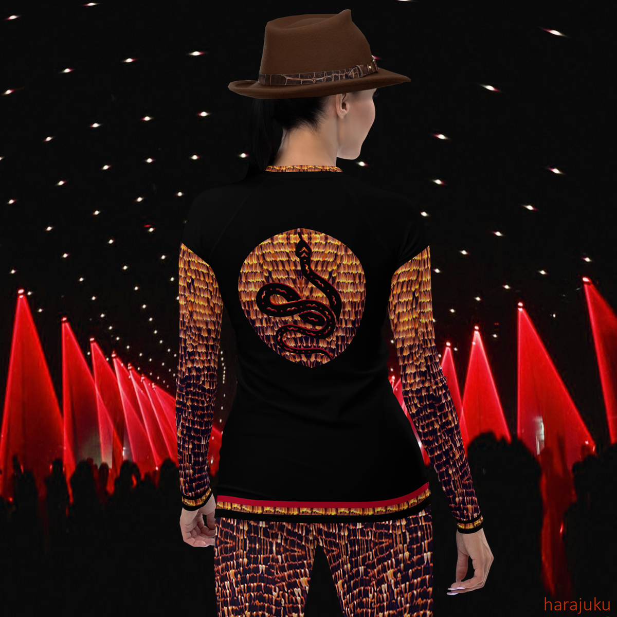 Back view of model wearing black DESTINY long sleeve crew top with snake design in gold copper tones, on a fashion runway
