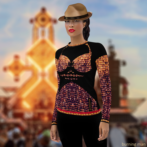 Left-front view of female model wearing black DESTINY long sleeve crew top with bra design in gold copper tones, at desert festival